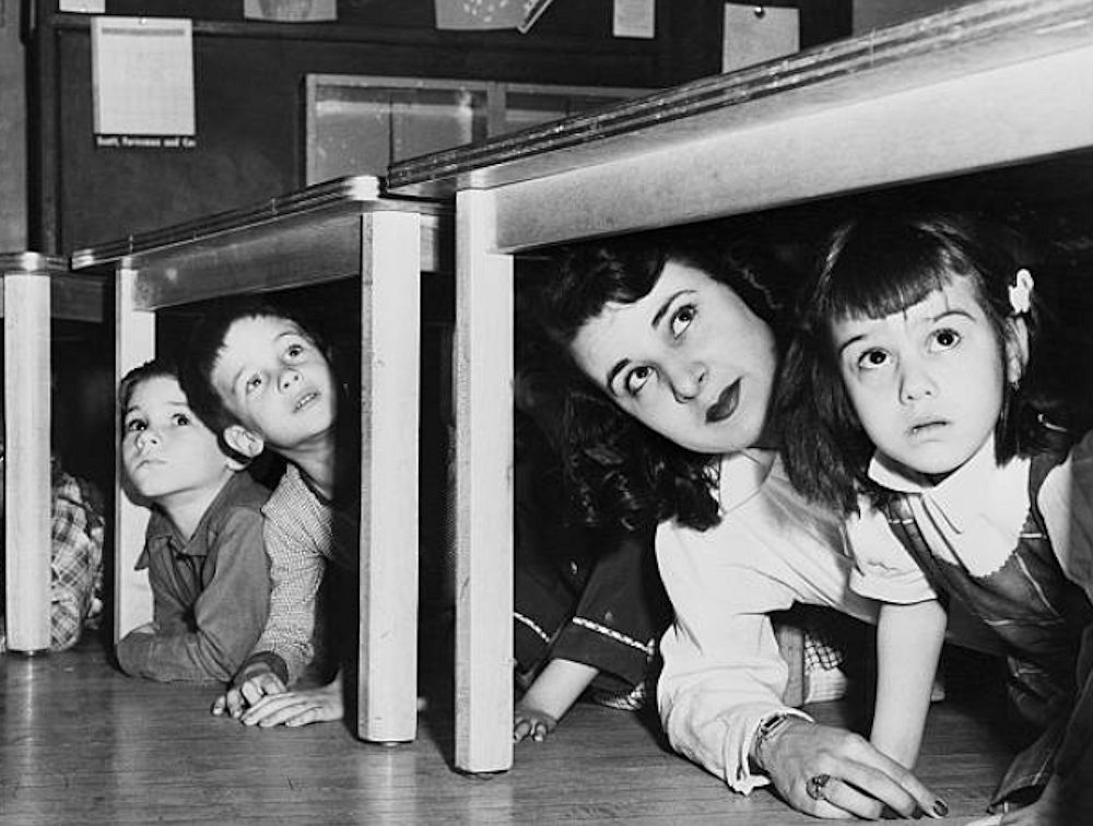 5/2/1952-Newark, NJ: School children and their teacher peer from beneath the table where they took refuge at Lafayette Street School when the sirens howled the alert in New Jersey's first state-wide air raid test.

Photo from Bettmann
